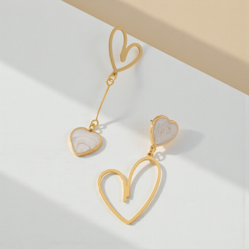 Boucles d'oreilles dorées asymétriques coeurs blancs