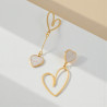 Boucles d'oreilles dorées asymétriques coeurs blancs